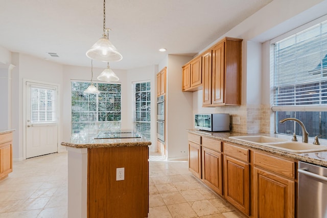 kitchen with visible vents, a kitchen island, a sink, appliances with stainless steel finishes, and backsplash