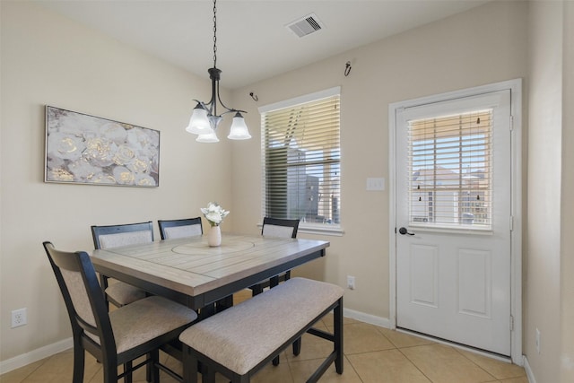 dining space featuring a notable chandelier, light tile patterned flooring, visible vents, and baseboards