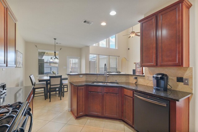 kitchen featuring visible vents, dark brown cabinets, gas range oven, dishwashing machine, and a sink