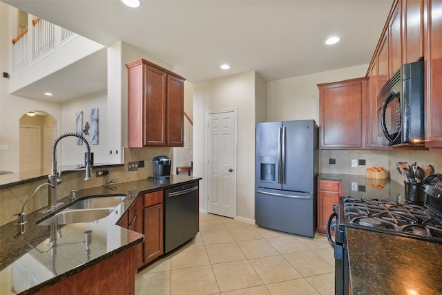 kitchen featuring dark stone countertops, light tile patterned flooring, recessed lighting, a sink, and black appliances