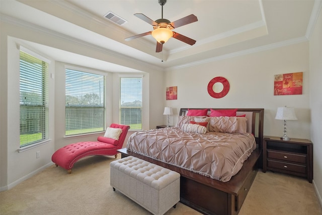 bedroom featuring a tray ceiling, ornamental molding, visible vents, and light carpet