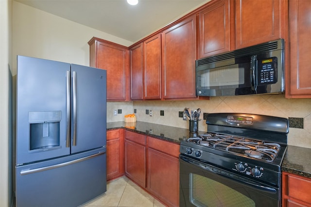 kitchen featuring backsplash, light tile patterned floors, dark stone countertops, black appliances, and reddish brown cabinets