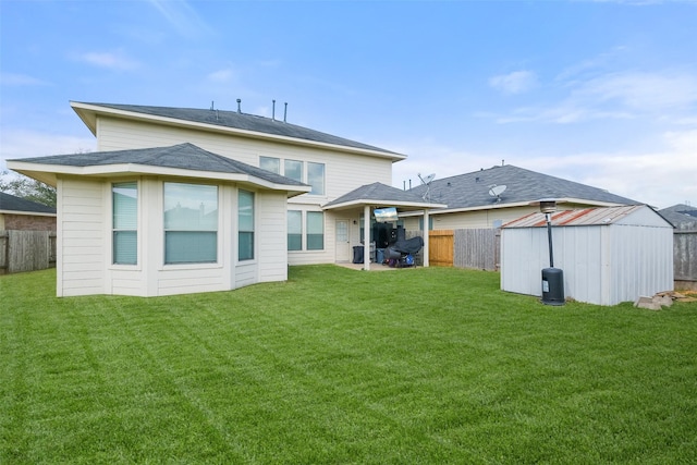 back of house featuring an outbuilding, a storage unit, a lawn, and a fenced backyard