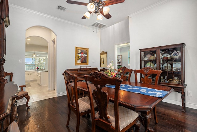 dining space with visible vents, arched walkways, wood-type flooring, and ceiling fan