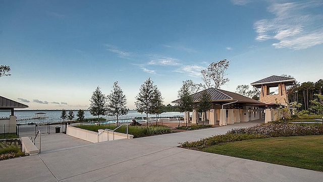 view of community featuring a lawn and a water view