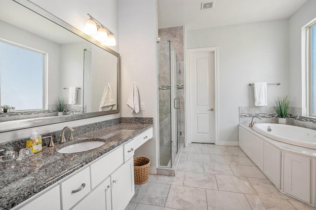 full bathroom with baseboards, a stall shower, vanity, and a garden tub