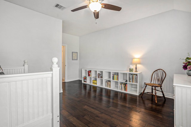 interior space featuring baseboards, visible vents, ceiling fan, wood-type flooring, and an upstairs landing