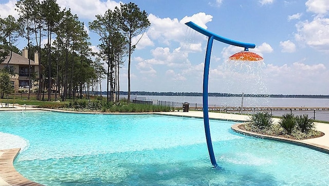 pool featuring fence and a water view