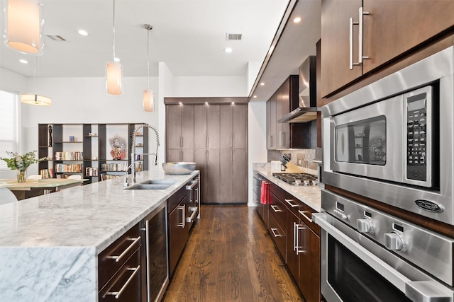 kitchen with wall chimney exhaust hood, beverage cooler, visible vents, and appliances with stainless steel finishes