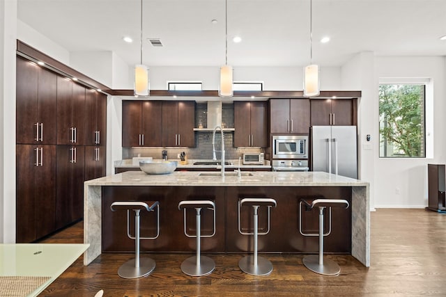 kitchen featuring visible vents, tasteful backsplash, dark wood finished floors, stainless steel appliances, and dark brown cabinets