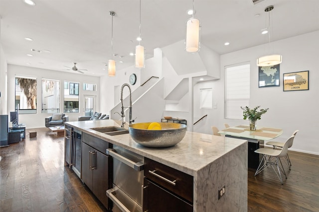 kitchen with a warming drawer, decorative light fixtures, dark wood-style flooring, and a sink