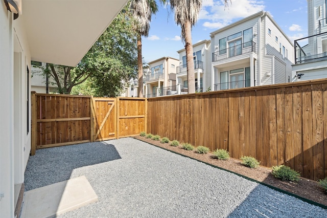 view of patio with a gate, fence, and a residential view