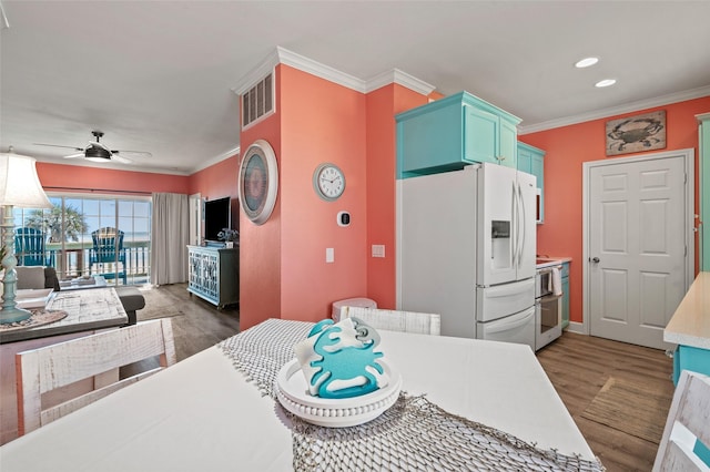 kitchen featuring ornamental molding, white refrigerator with ice dispenser, a ceiling fan, and wood finished floors