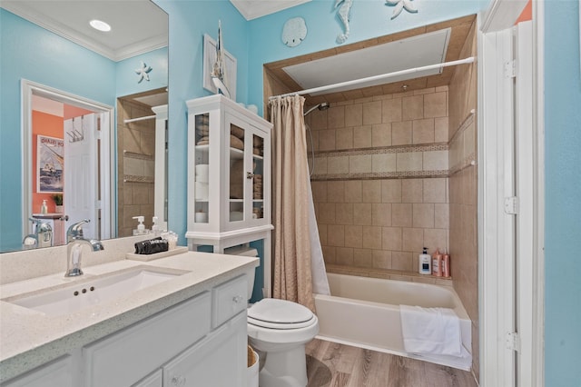 full bath featuring vanity, wood finished floors, shower / bath combo with shower curtain, crown molding, and toilet