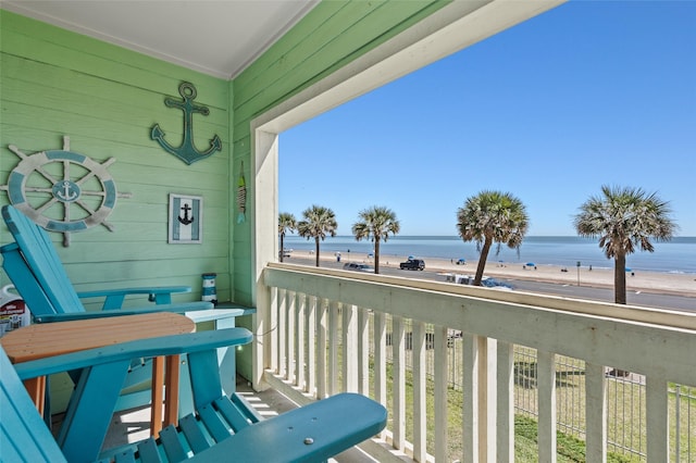 balcony featuring a view of the beach and a water view