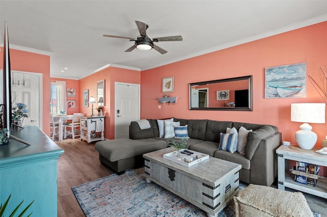 living area with a ceiling fan, crown molding, and wood finished floors