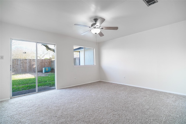 empty room with visible vents, carpet floors, baseboards, and ceiling fan