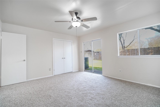 unfurnished bedroom featuring access to outside, carpet flooring, a ceiling fan, and baseboards