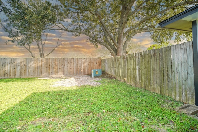 yard at dusk with a fenced backyard