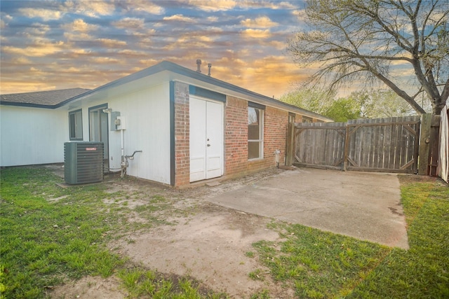 outdoor structure at dusk featuring central AC and fence