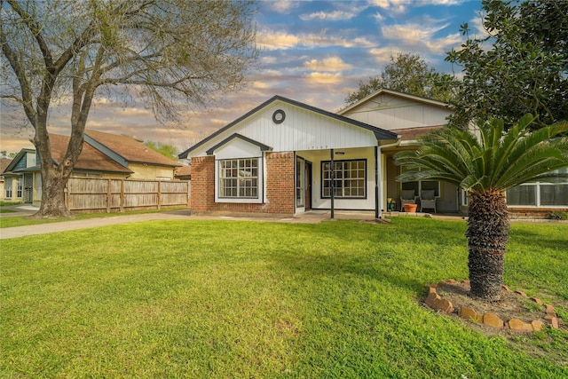 view of front of home featuring a front lawn and fence