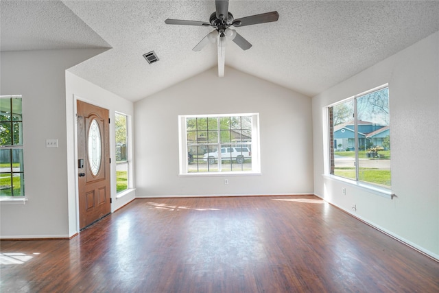 entryway with a wealth of natural light, visible vents, lofted ceiling with beams, and wood finished floors