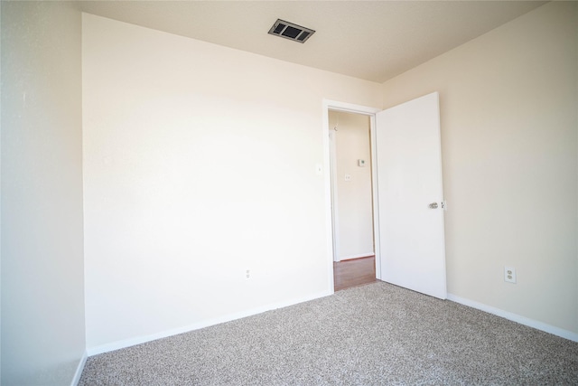 empty room featuring visible vents, baseboards, and carpet