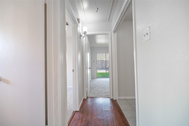 corridor with baseboards, attic access, and wood finished floors