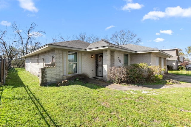 single story home with brick siding, a front yard, and fence