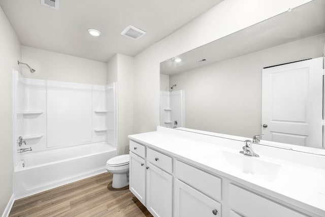 bathroom featuring visible vents, toilet, shower / bathing tub combination, wood finished floors, and vanity