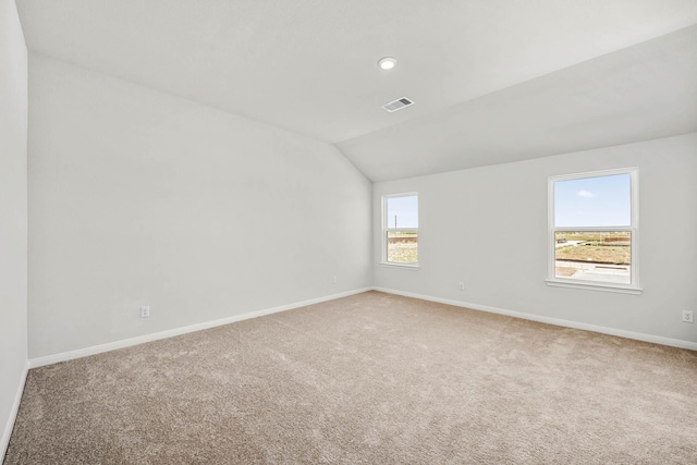 empty room featuring visible vents, recessed lighting, carpet, baseboards, and vaulted ceiling