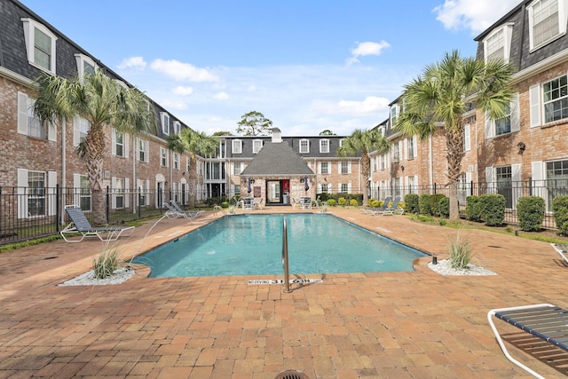 pool featuring a residential view, a patio, and fence