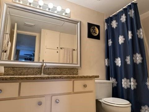 full bath with a shower with shower curtain, visible vents, toilet, and vanity