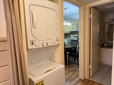 laundry area featuring laundry area, stacked washer / drying machine, and wood finished floors