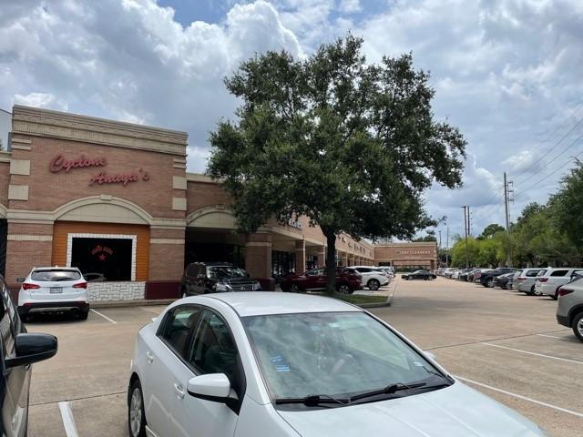 exterior space with uncovered parking and brick siding