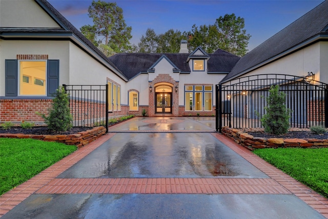 exterior space featuring brick siding, stucco siding, and french doors