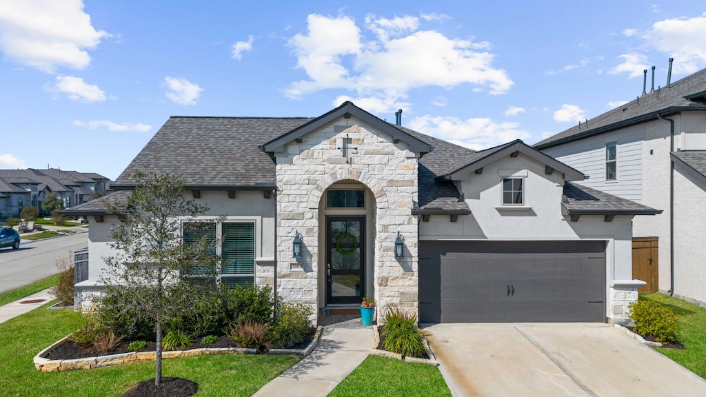2003 Green Haven Ct, Missouri City, TX 77459 - french country home with stone siding, stucco siding, driveway, and a shingled roof