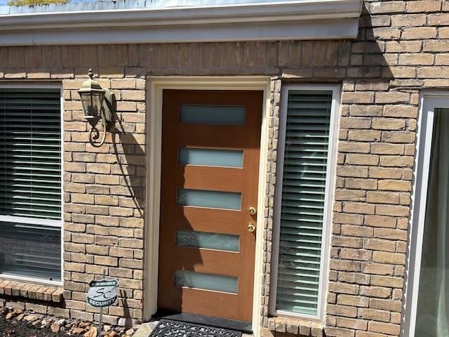 entrance to property featuring brick siding