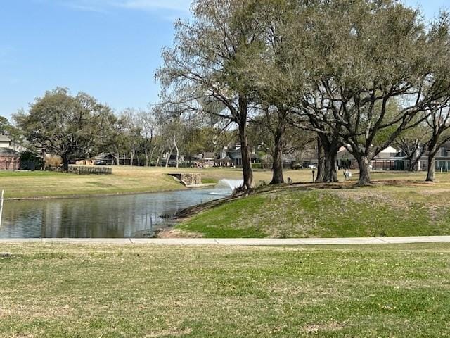 view of home's community featuring a water view and a lawn