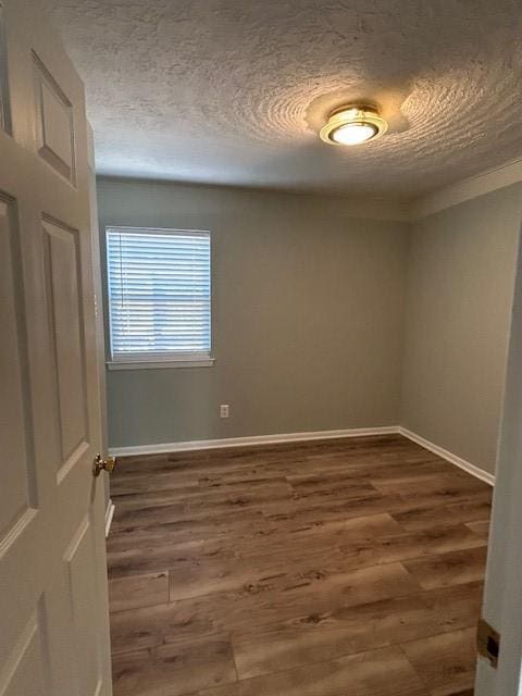 unfurnished room with dark wood-type flooring and a textured ceiling