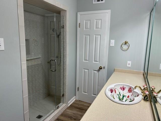 bathroom with visible vents, a stall shower, vanity, and wood finished floors