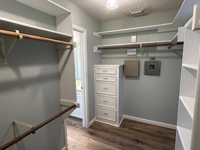 walk in closet with wood finished floors