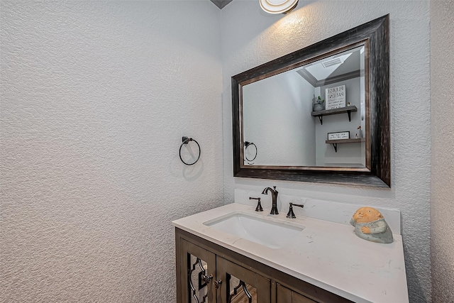 bathroom with vanity and a textured wall