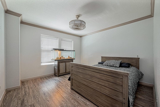 bedroom with a textured ceiling, light wood-type flooring, baseboards, and ornamental molding