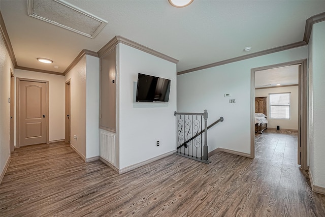 corridor with baseboards, an upstairs landing, attic access, and wood finished floors