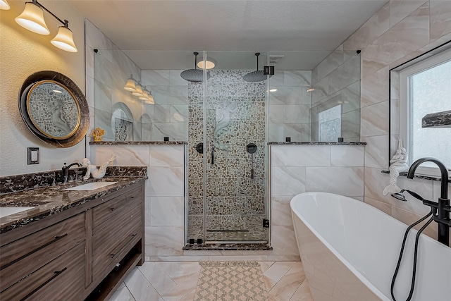 full bath with a stall shower, a sink, tile walls, double vanity, and a freestanding bath