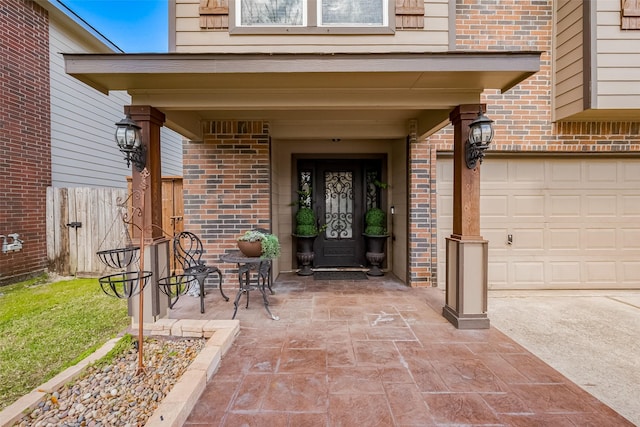 doorway to property featuring a garage and brick siding