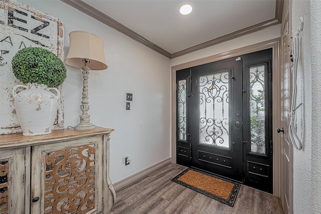 foyer featuring crown molding, baseboards, and wood finished floors