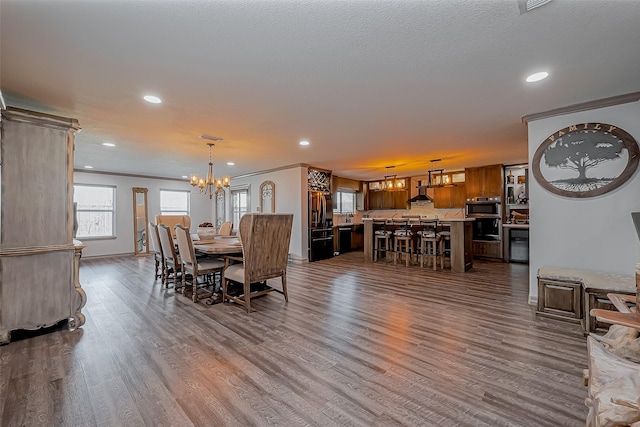 dining space with dark wood-style floors, crown molding, and an inviting chandelier