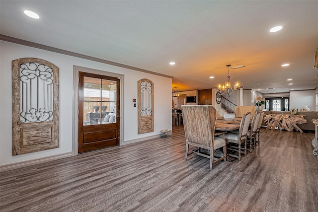 dining area with ornamental molding, wood finished floors, recessed lighting, an inviting chandelier, and baseboards